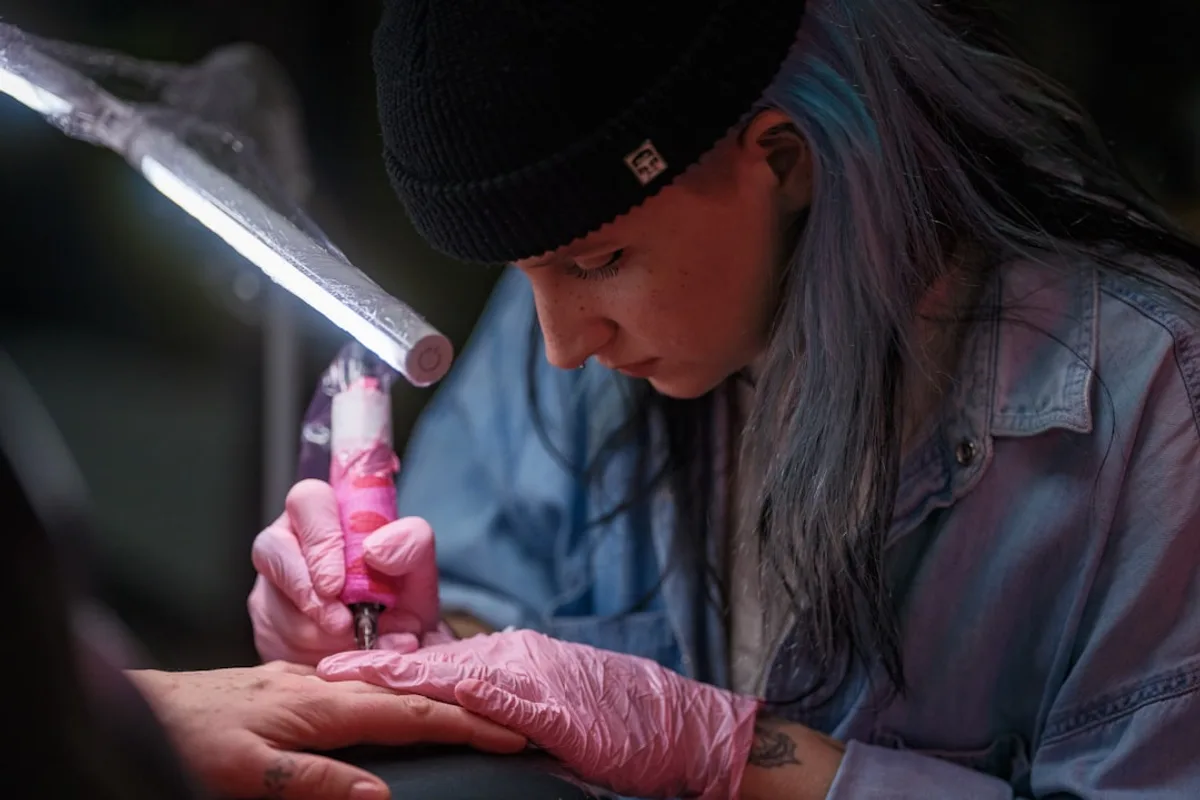 A woman in a black hat and pink gloves
