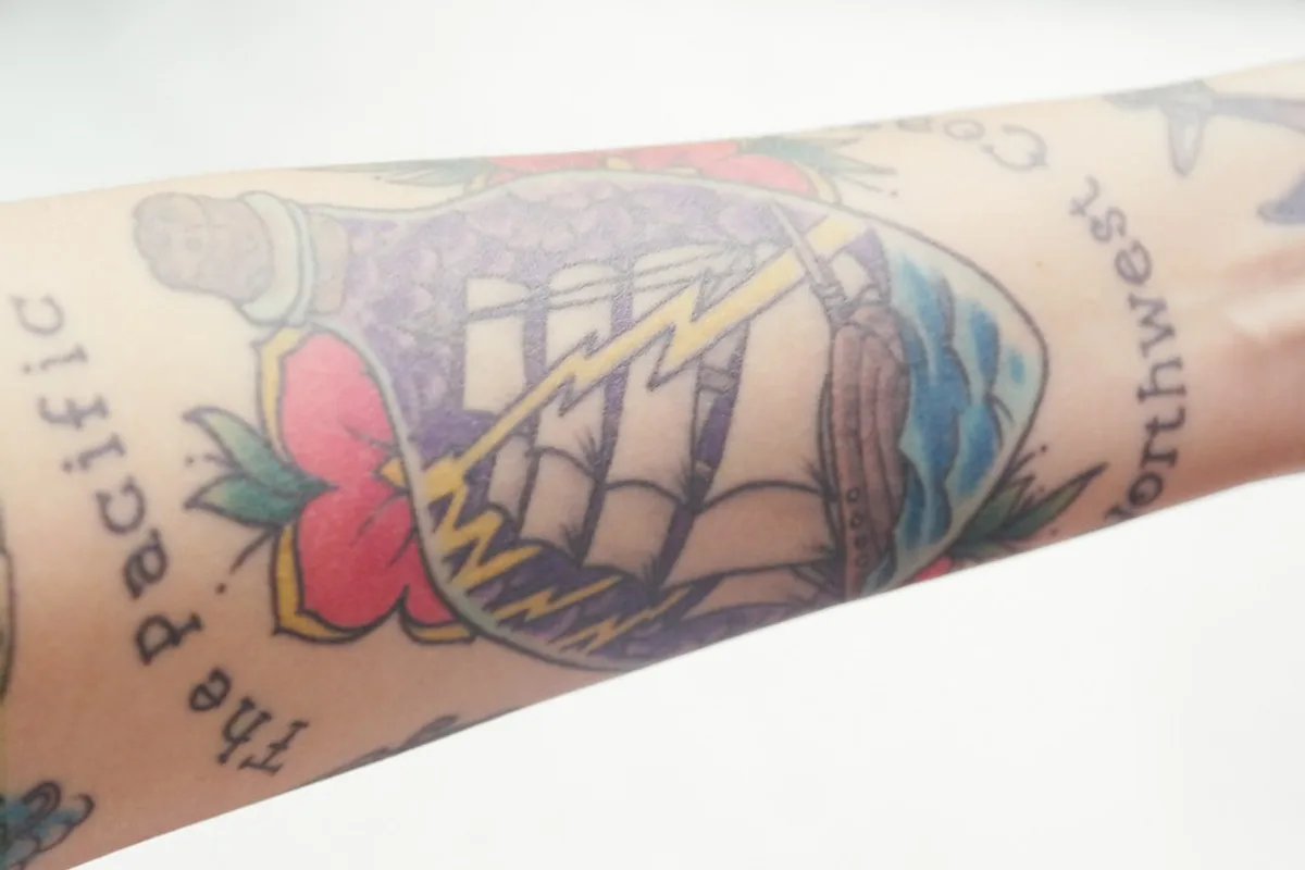 a close up of a person's arm with tattoos on it