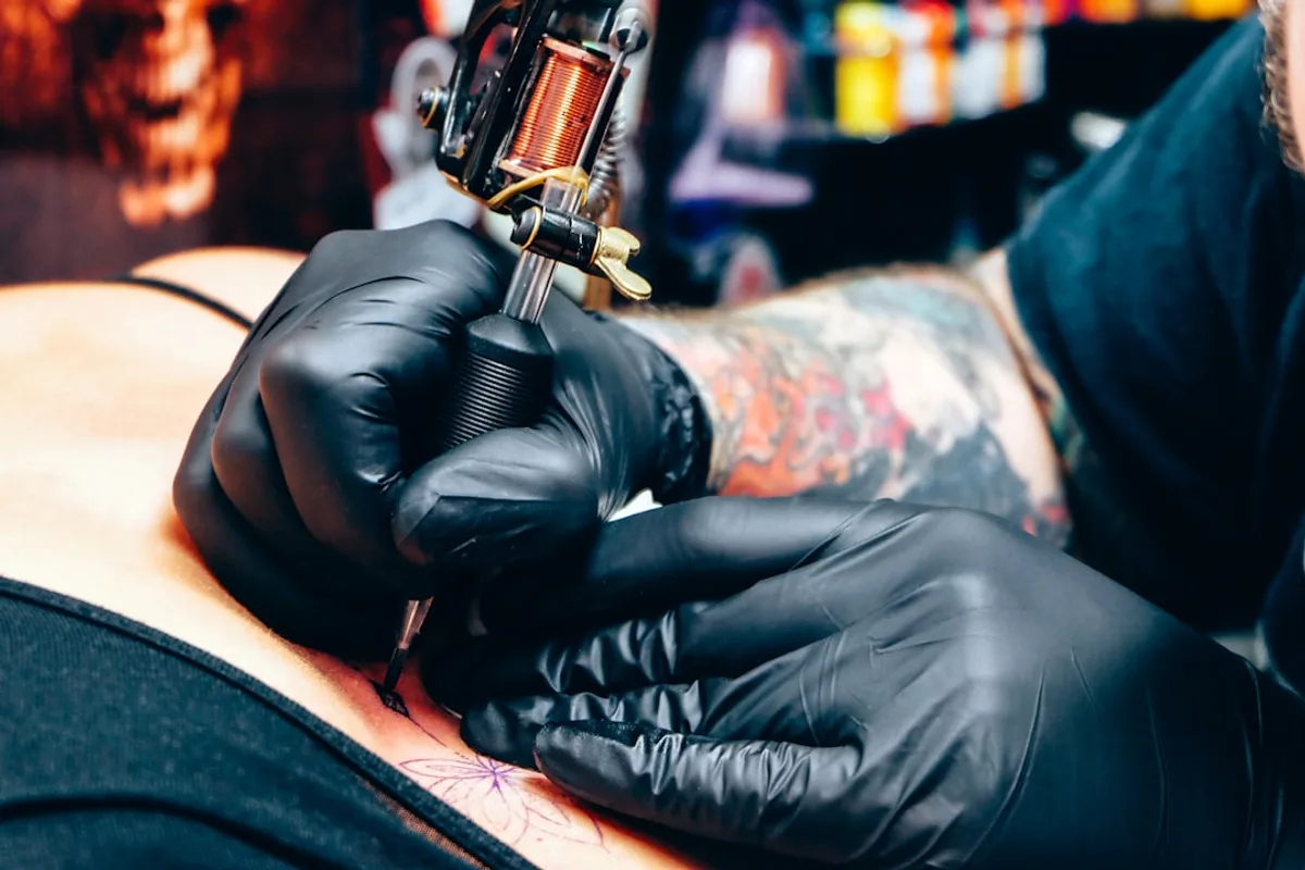 A man with a tattoo on his arm holding a gun