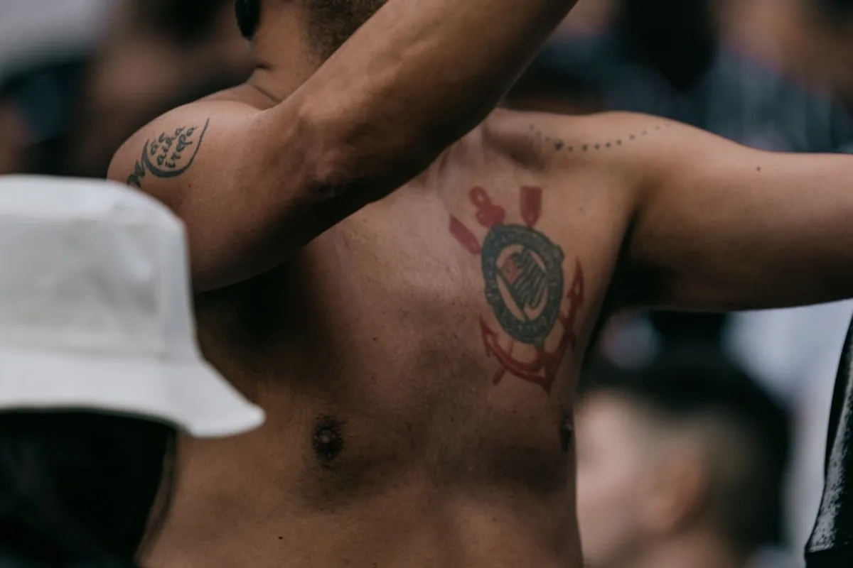 A shirtless man holding a cell phone to his ear