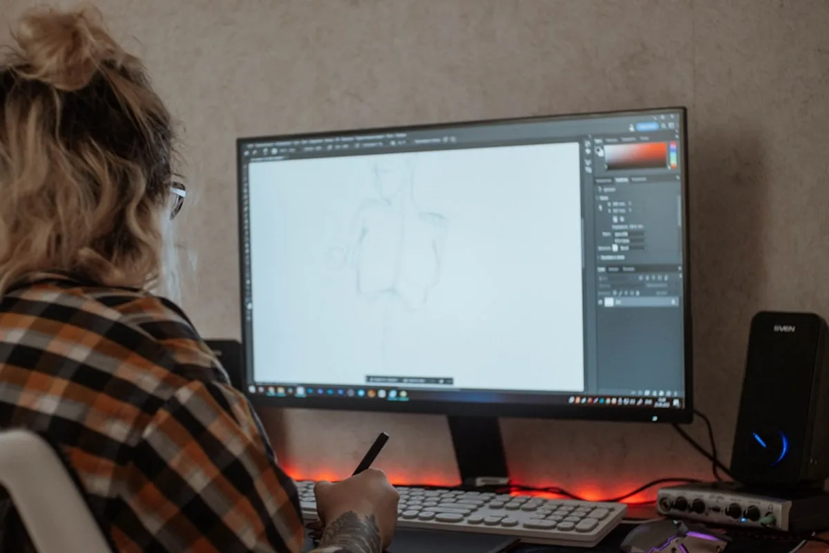 a woman sitting in front of a computer monitor