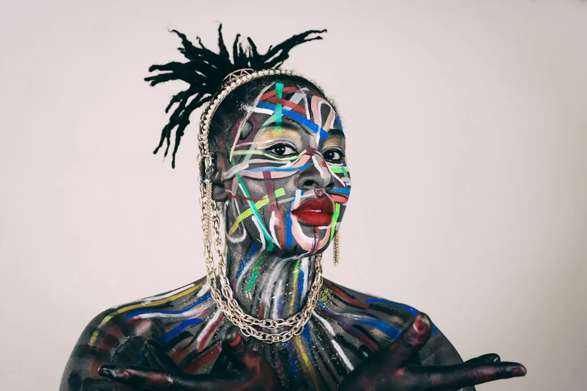 Woman displays striking body paint and bold makeup.