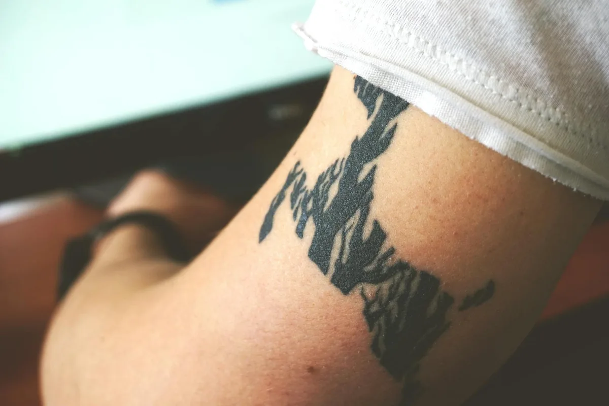 Detailed close-up of an abstract black arm tattoo on a person's skin, showcasing personal body art.