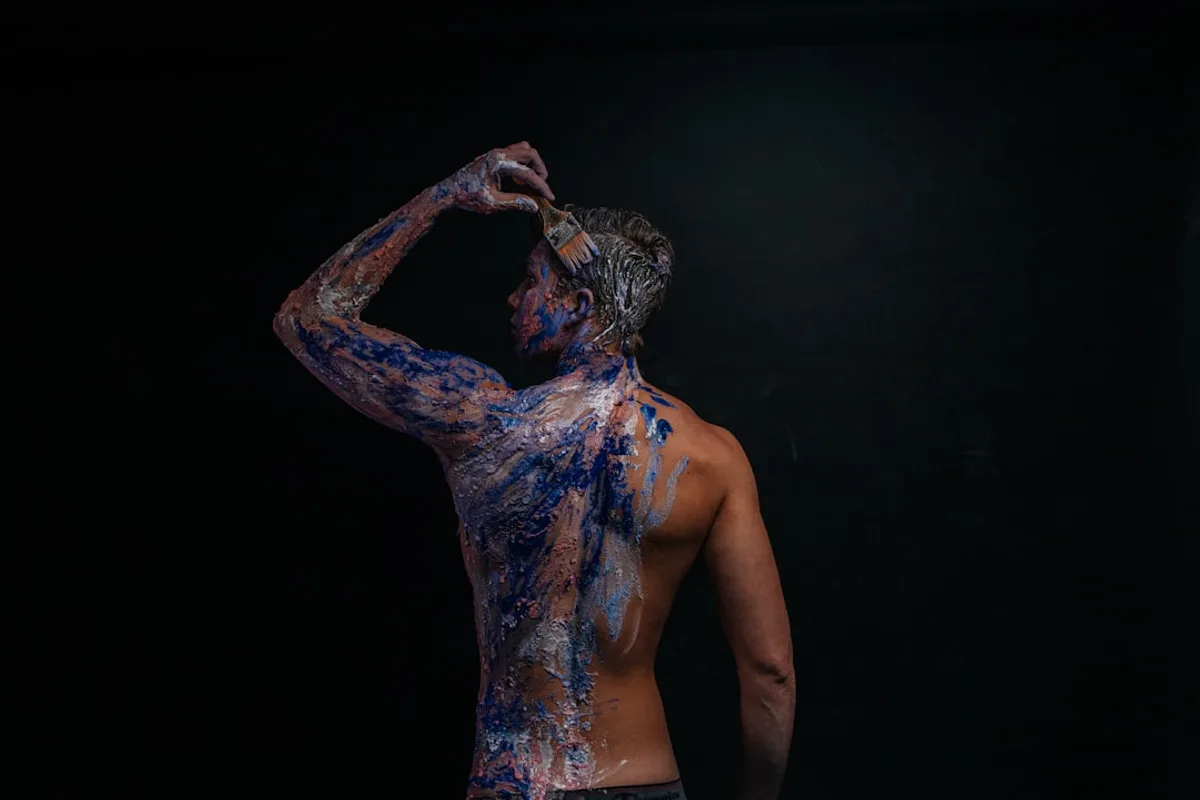 a man is covered in blue and purple paint