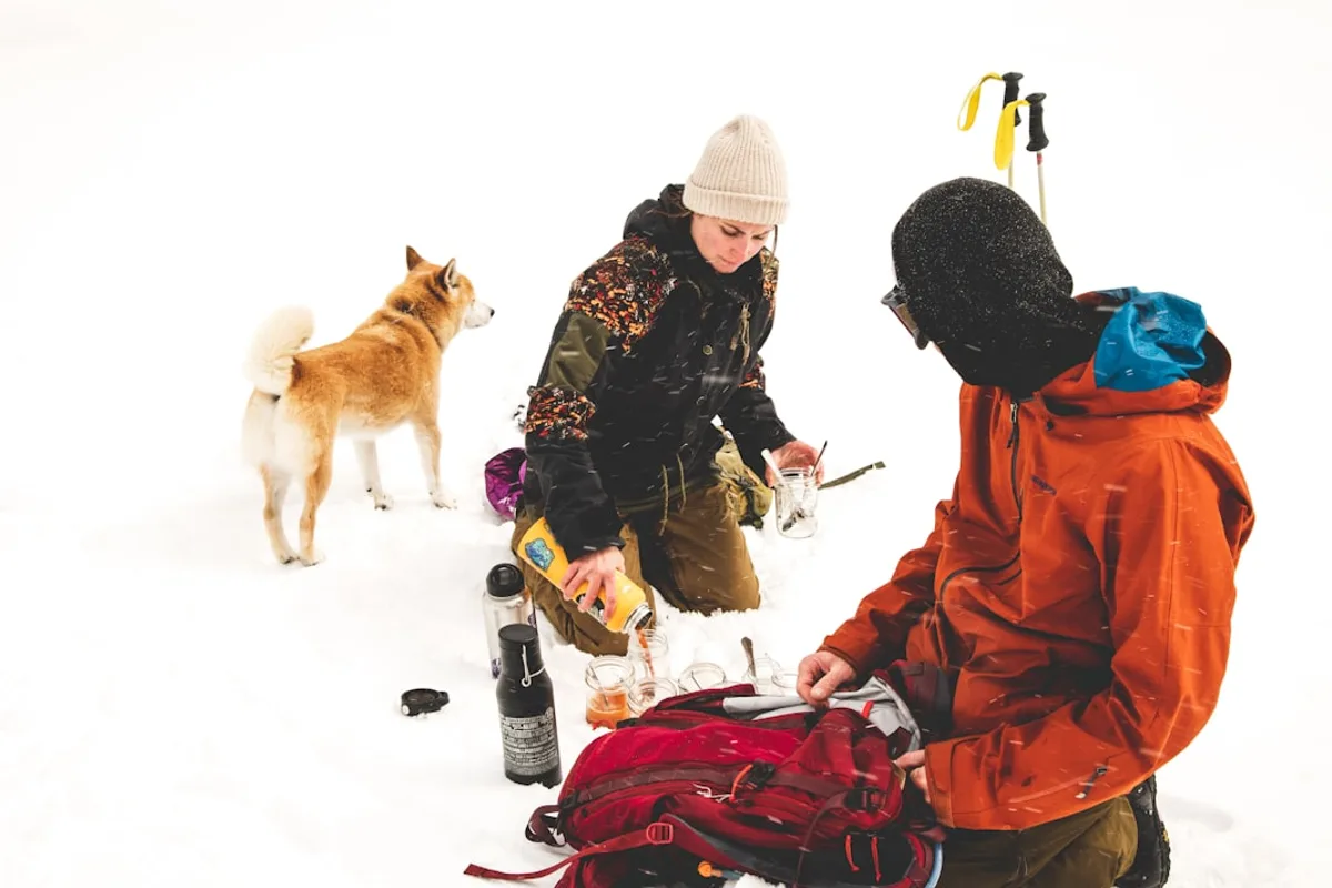 two persons sitting on snowy ground