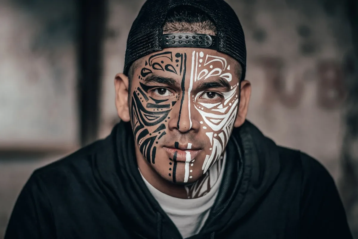 man with black and white face tattoo