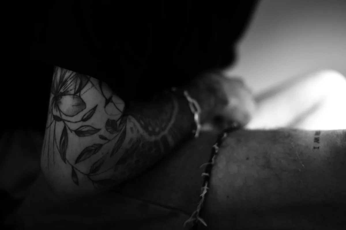 a man with a flower tattoo on his arm