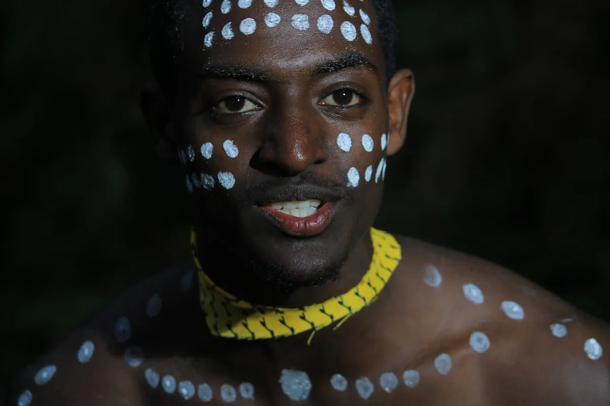 woman in yellow tank top with black and white face paint