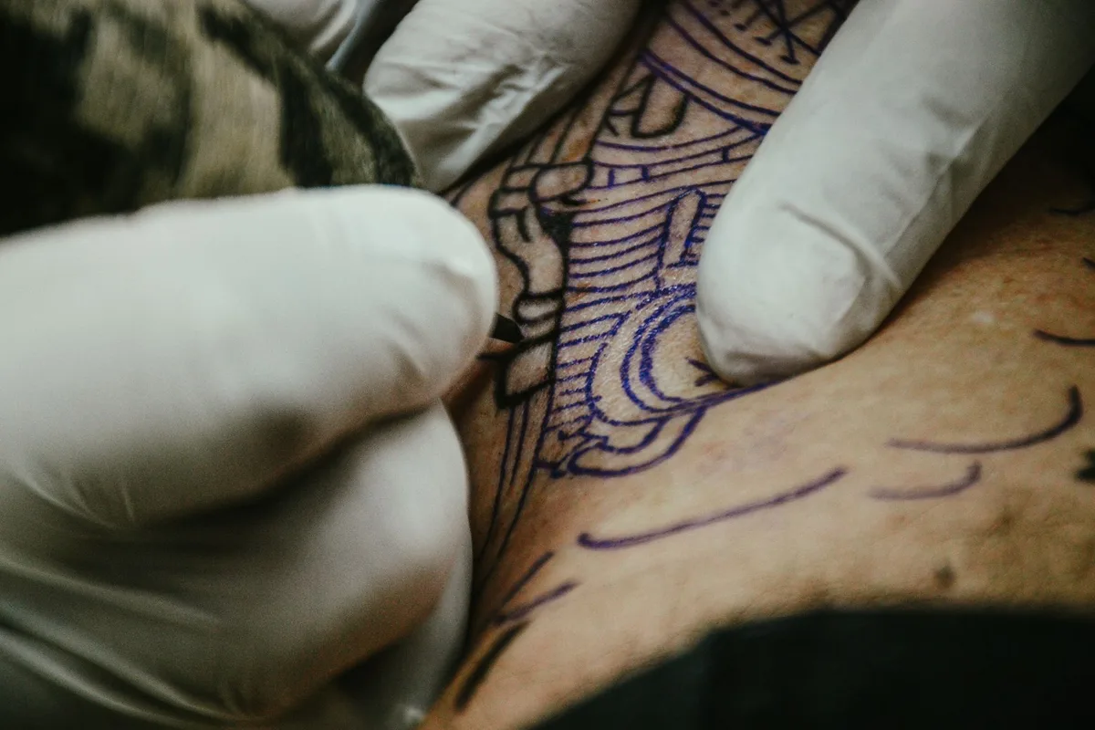 A detailed view of a tattoo artist applying ink, showcasing tattoo artistry up close.