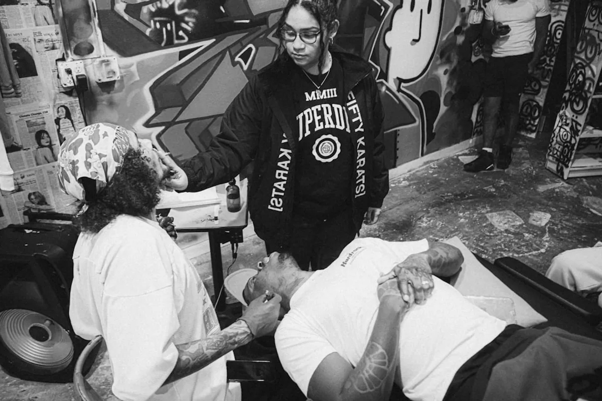 a black and white photo of a man getting his hair cut
