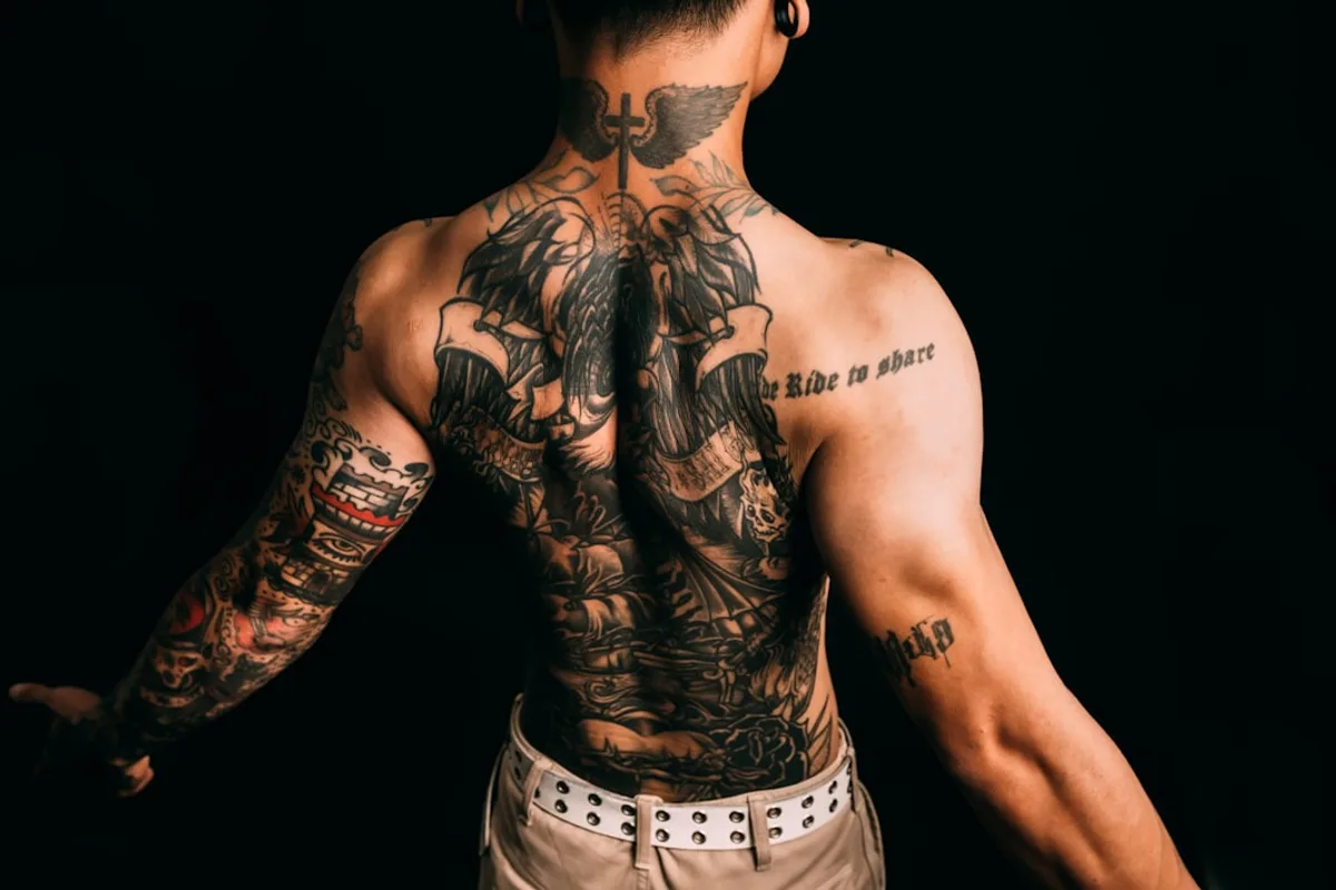 Man with elaborate full back and arm tattoos