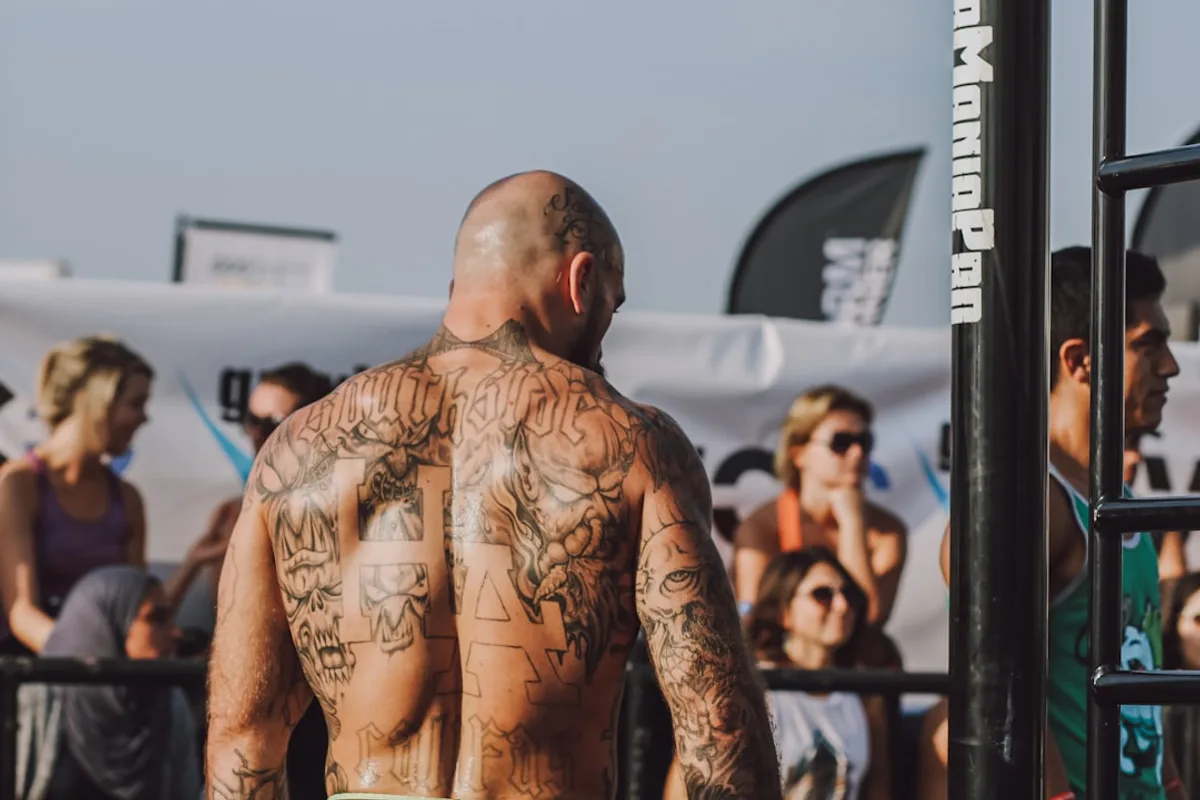 man in black shorts standing near black metal fence during daytime