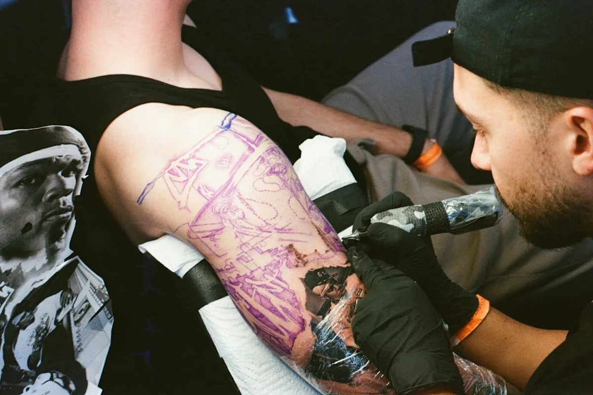 Tattoo artist working on a client's arm
